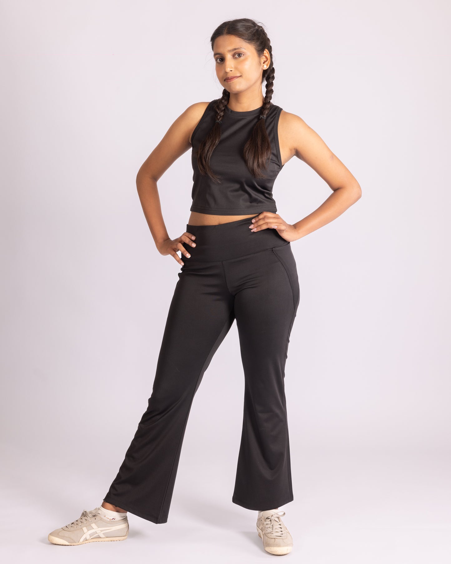 Rachel Co-ord Set – Black, featuring high-waisted flared trousers and a sleek sleeveless crop top. Designed with premium stretch fabric for comfort and a flattering fit, this versatile set is perfect for athleisure, casual outings, or elevated everyday wear.