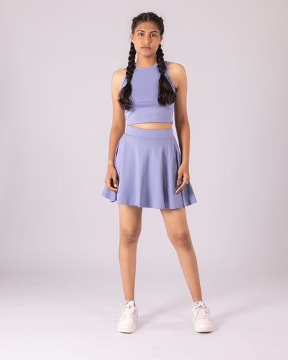 Women's lavender 2-in-1 tennis skort and seamless gym crop top set, featuring high-waisted tummy-control skort with built-in compression shorts, moisture-wicking stretch Lycra fabric, and a sculpting sleeveless crop top. Designed for high-performance workouts, tennis, yoga, gym training, running, and athleisure styling.