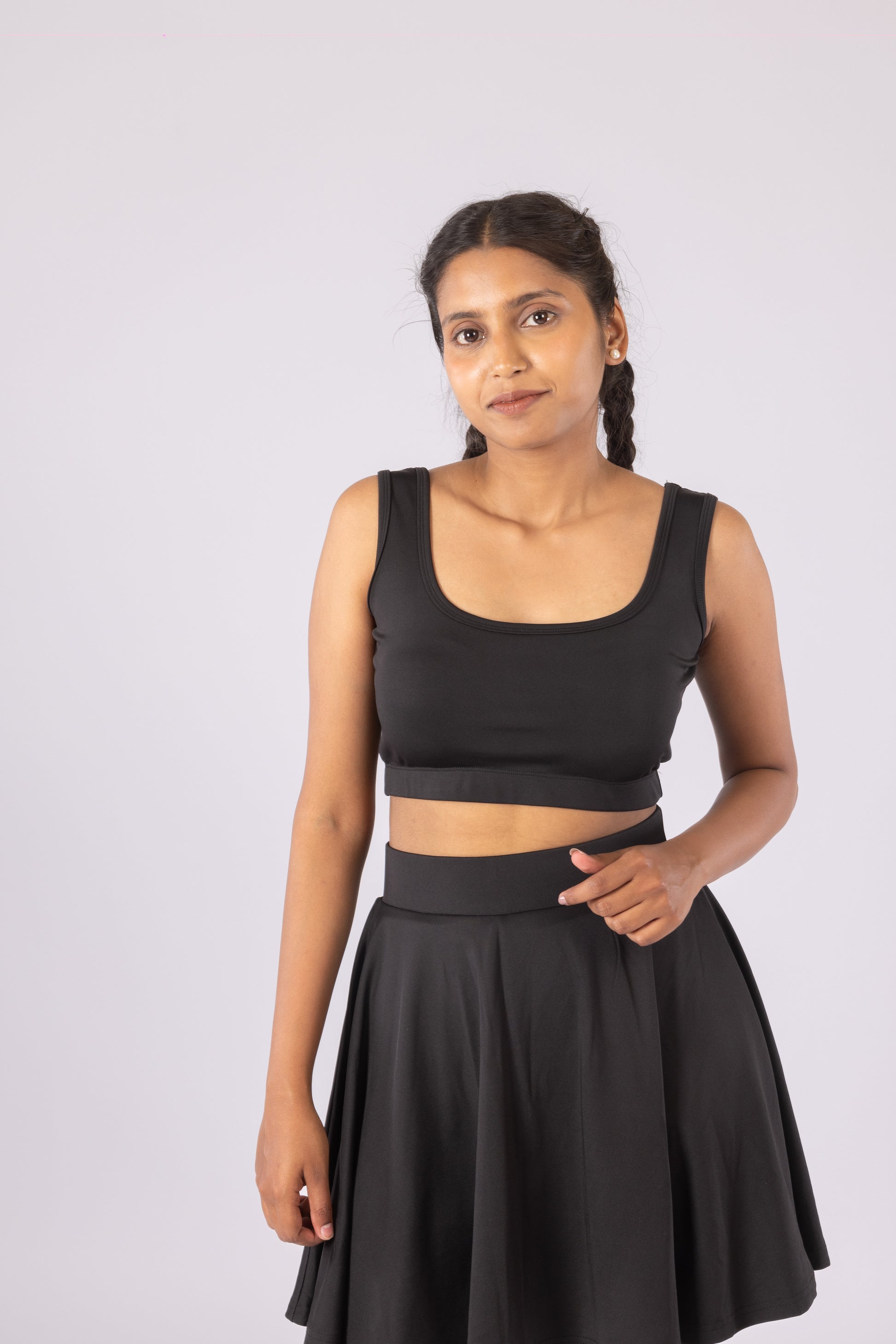  Women’s 2-in-1 activewear co-ord set featuring a high-waisted tennis skort with built-in shorts and a fitted crop top in black.